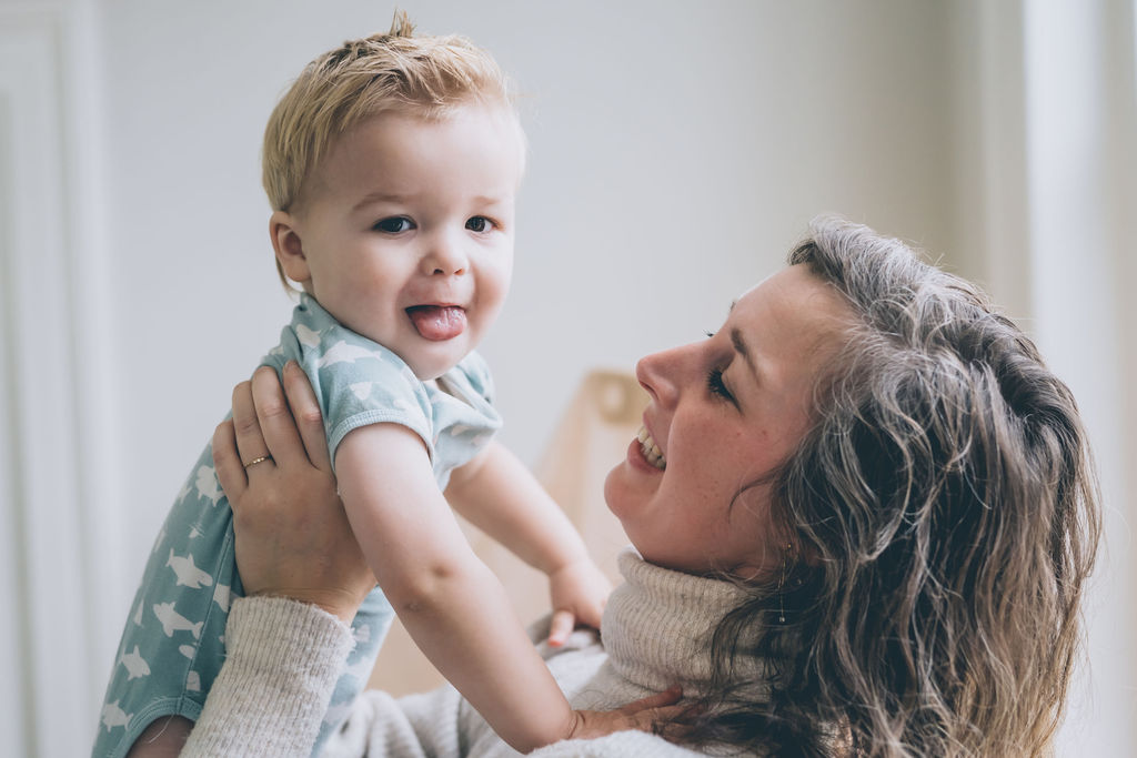 little baby boy smiling, lifted by his mother little baby boy smiling, lifted by his mother