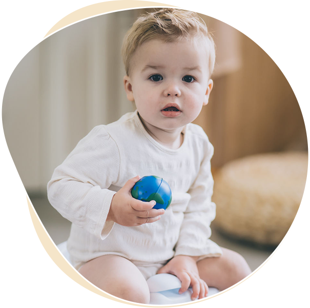 A mother and child are sitting, both laughing and smiling while looking at each other during potty training. The child is holding a towel napkin, while the mother has her arm around the child's back. They are happy to choose the right potty training method. tips for busy parents