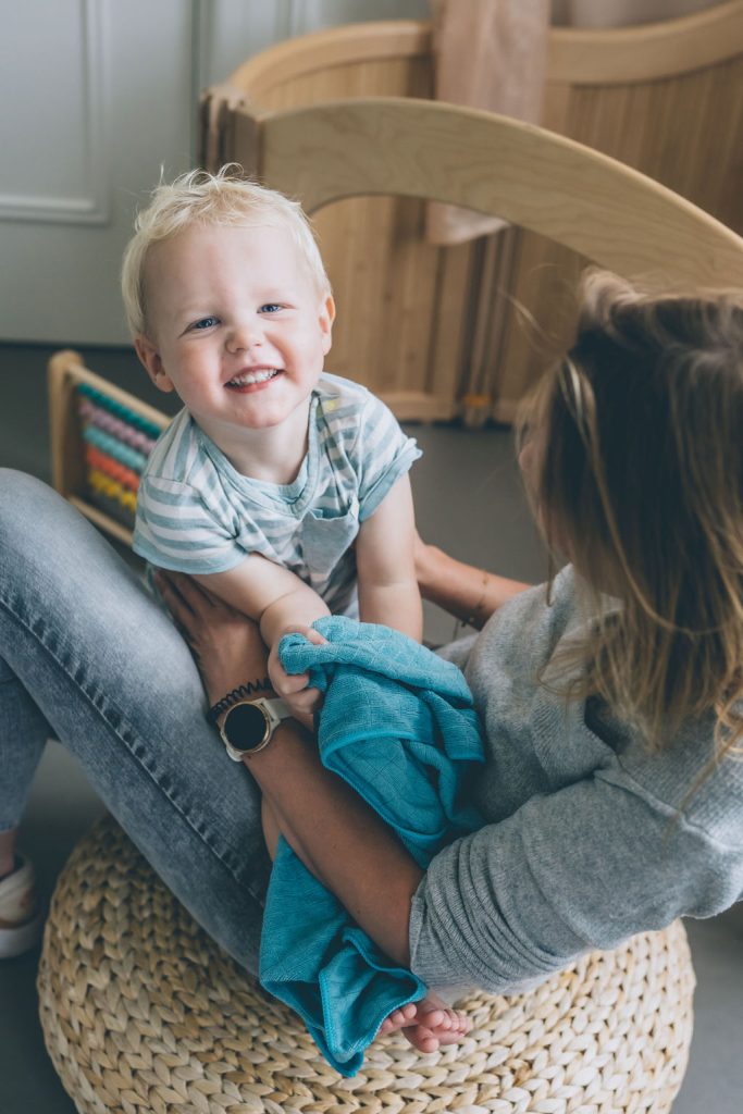 Child with mother. Boy smiling, mother is holding him on her lap. Potty training app.