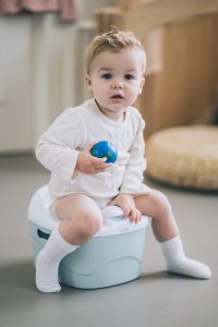 Child Sitting On Potty Holding Globe