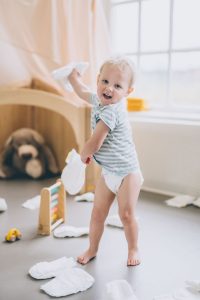 Happy Child Throwing Nappies Around 