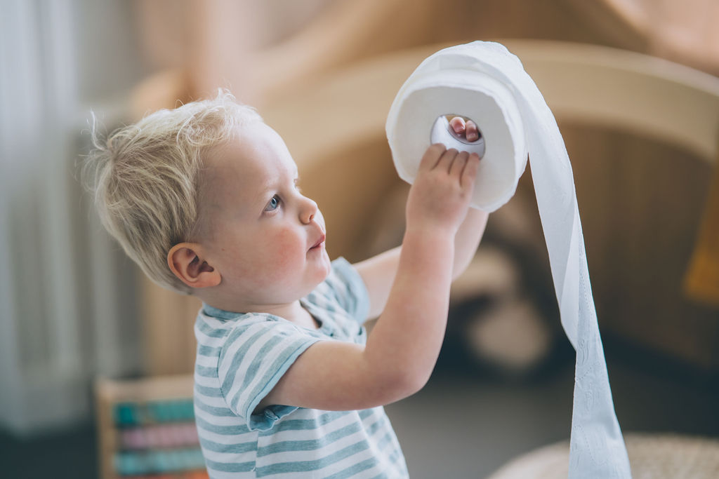 Fotoshoot-MoniekvanSelmFotografie Child holding a roll of toilet paper. Potty training a child diagnosed with autism spectrum disorder.